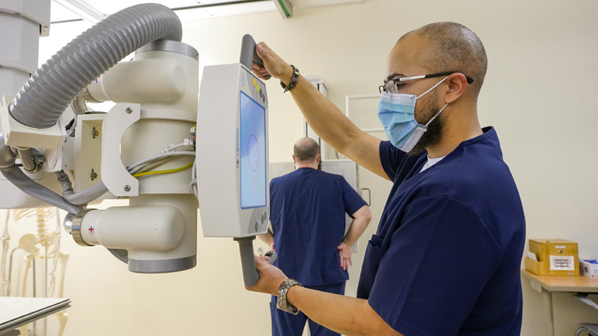 A rad tech student uses an X-ray machine