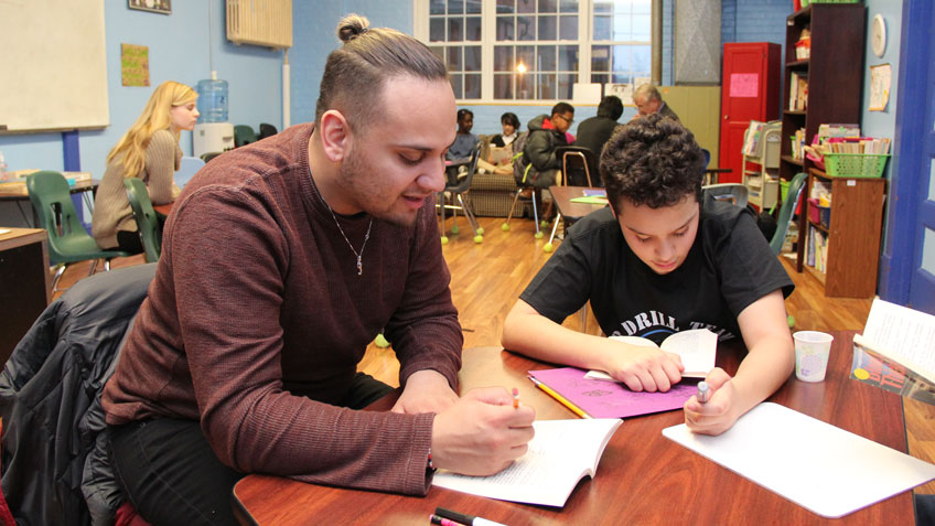 Jonathan Mendez helps a middle schooler at Homework House
