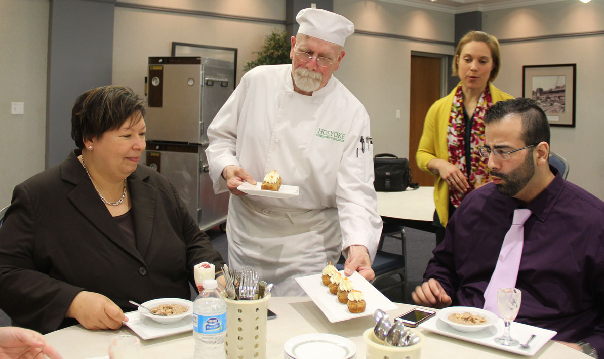 HCC Culinary Arts student Scott Buchanan of Ludlow serves mini carrot muffins to guest judges, President Christina Royal and her staff assistant Nelson Lopez. 