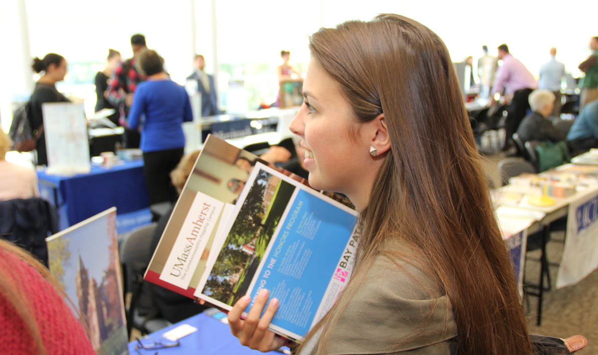 A student at HCC's annual Transfer Fair holds materials from the University of Massachusetts.