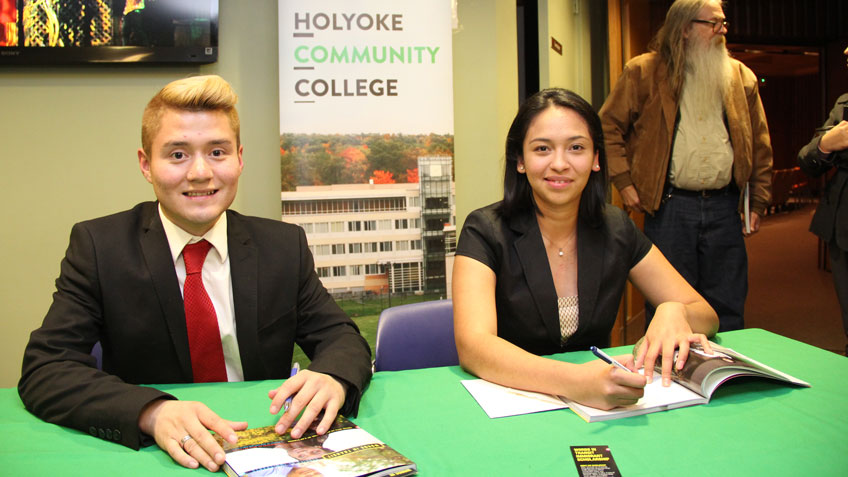 Bryan Torres, '14, and Angelica Merino Monge, '17, sign copies of Words in Transit: Stories of Immigration.