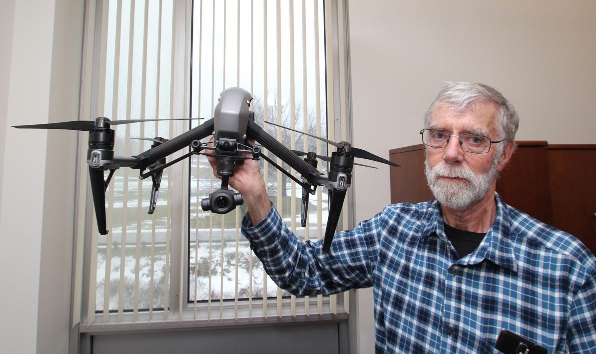 Drone pilot instructor Larry Harmon holds a drone.  