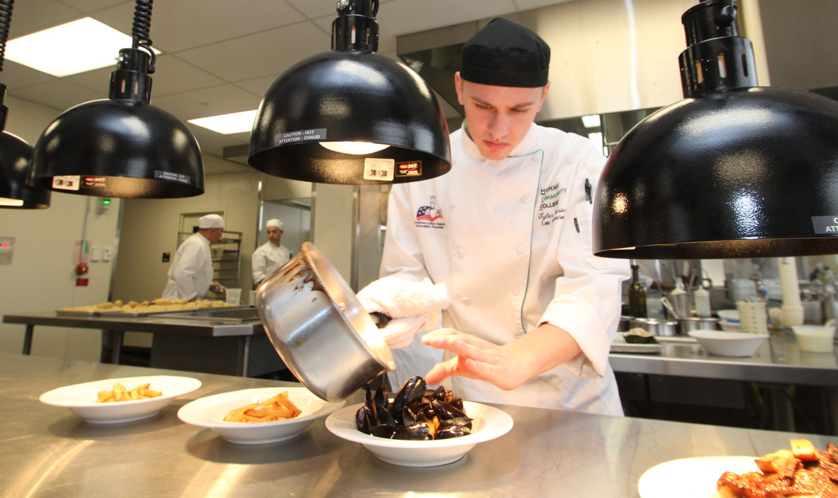 HCC lab tech and culinary arts alumnus Tyler Carrier prepares mussels for a lunch at the HCC MGM Culinary Arts Institute. 