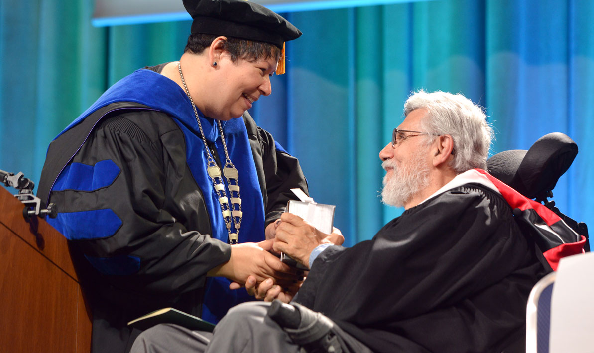 President Christina Royal presents the Distinguished Service Award to Chris Palames at Commencement June 2. 