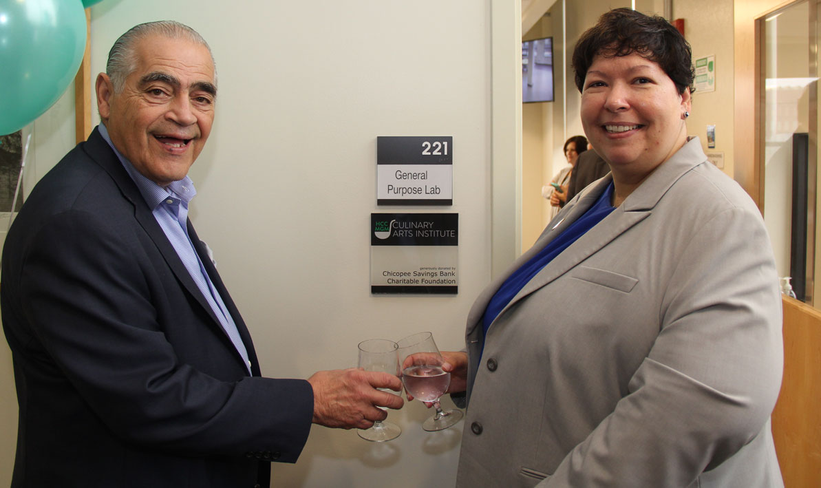 William Wagner, president of Chicopee Savings Bank Charitable Foundation, and HCC president Christina Royal toast a plaque recognizing the foundation's $50,000 donation to the HCC MGM Culinary Arts institute. 
