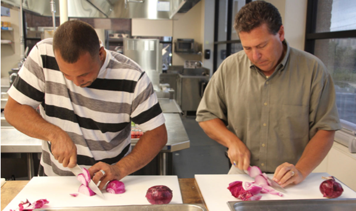 Enrique Melendez, left, a Holyoke Department of Public Works employee, and Jim Crowley, of Holyoke Gas & Electric, slice onions during a health cooking class at the HCC MGM Culinary Arts Institute hosted by Training and Workforce Options