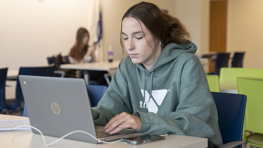 A student uses a laptop in the campus center