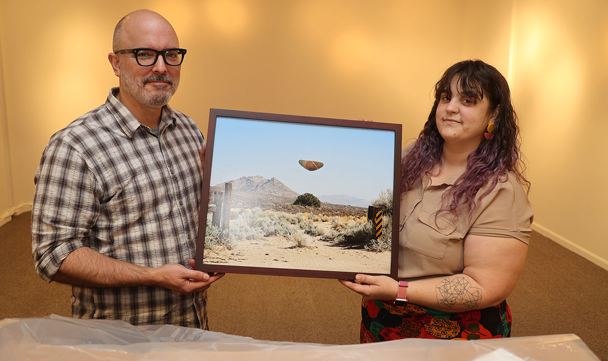 Thrive Center coordinator Ben Ostiguy and Taber Art Gallery director Rachel Rushing unwrap artwork for a new exhibit. 