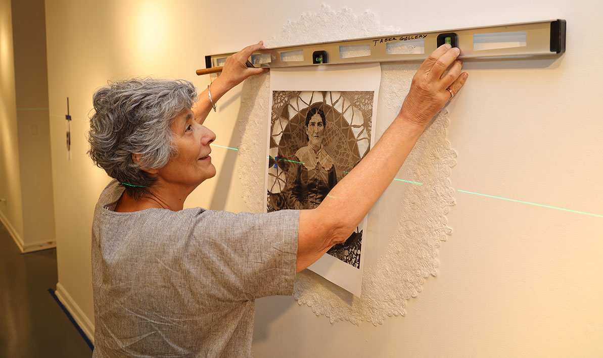 Felice Caivano installs a piece for the Taber Art Gallery's 25th anniversay exhibition.
