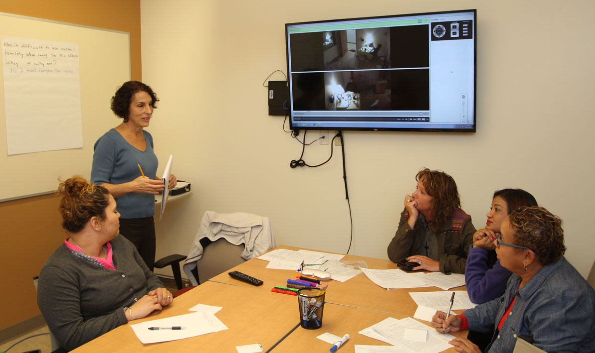 Janet Grant, coordinator of HCC's Community Health Worker program, consults with students during a class. 