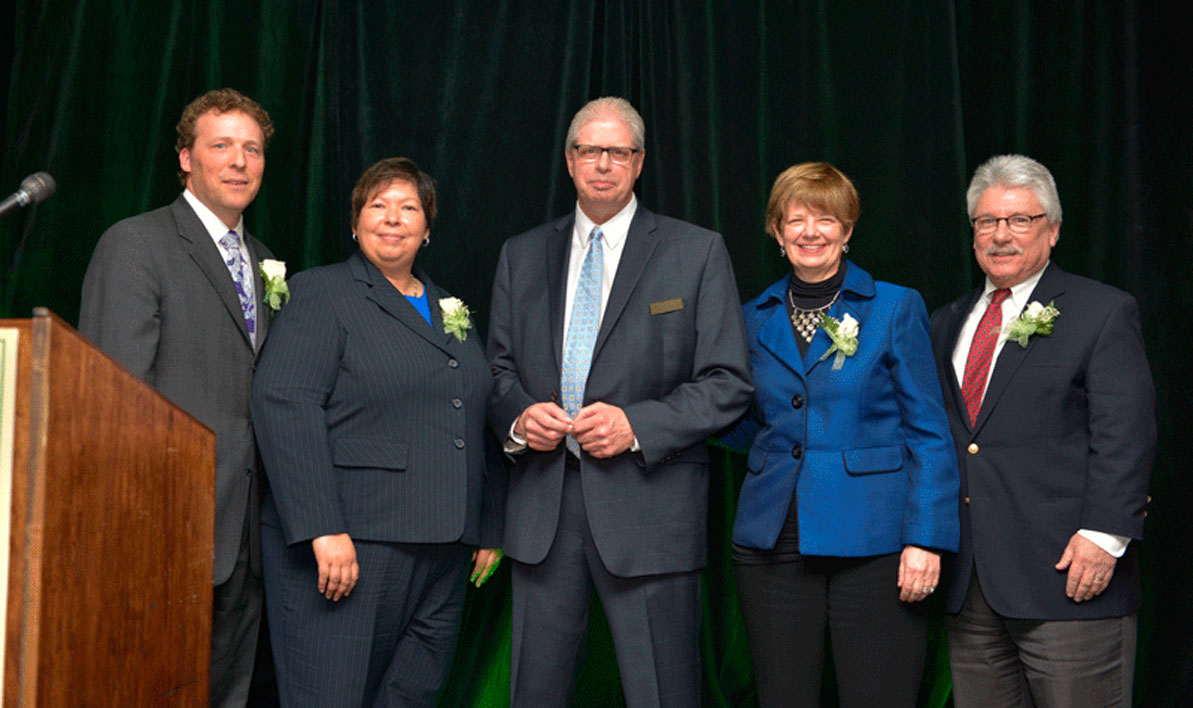 Business West editor George O'Brien, center, presents a 2017 Difference Maker award to the presidents of the four western Massachusetts community colleges last week during an awards banquet at the Log Cabin in Holyoke.