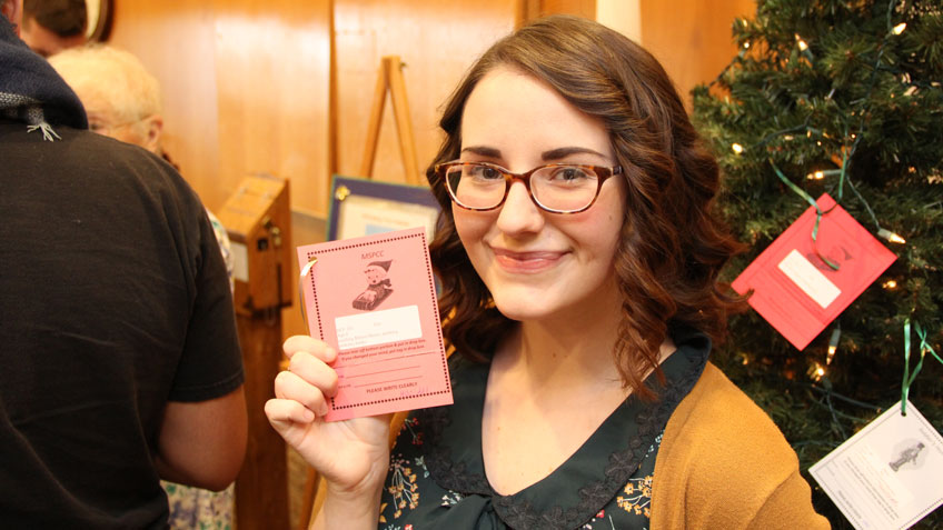 HCC Student Senate president Natalie Richards holds up the gift tag she chose from the Giving Tree.