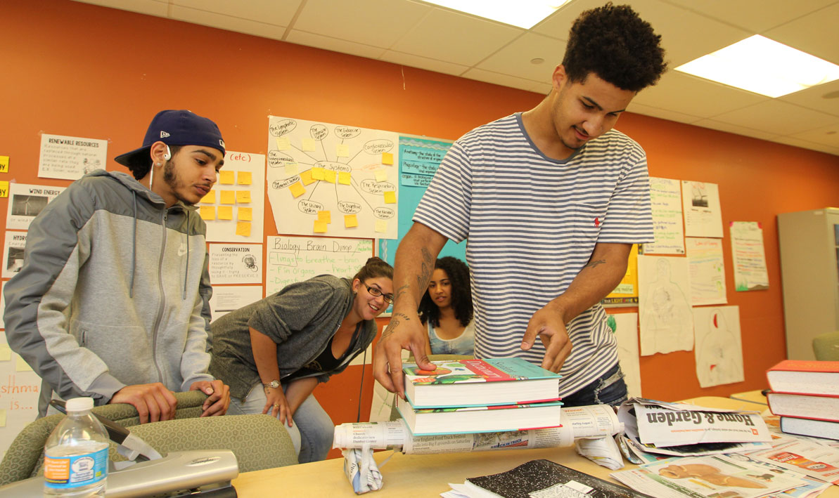 Justin Braithwaite adds books to his newspaper bridge during a summer program at PAFEC.