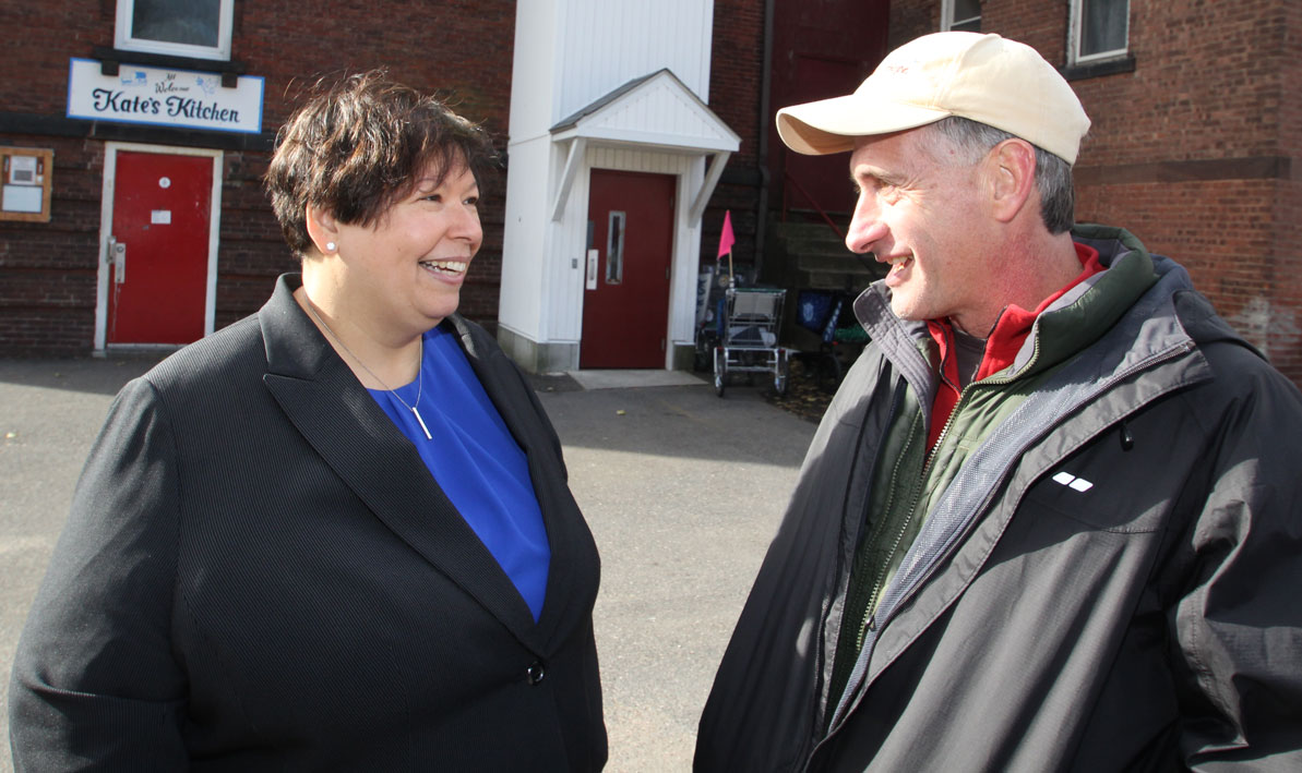 HCC president Christina Royal talks to Andrew Moorehouse, executive director of the Food Bank of Western Massachusetts, outside Kate's Kitchen in Holyoke during Monte's March.