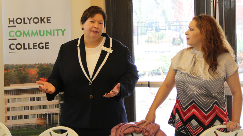 HCC president Christina Royal talks to program participants at Nuestras Raices as Hilda Roque, executive director of Nuestras Raices, looks on.