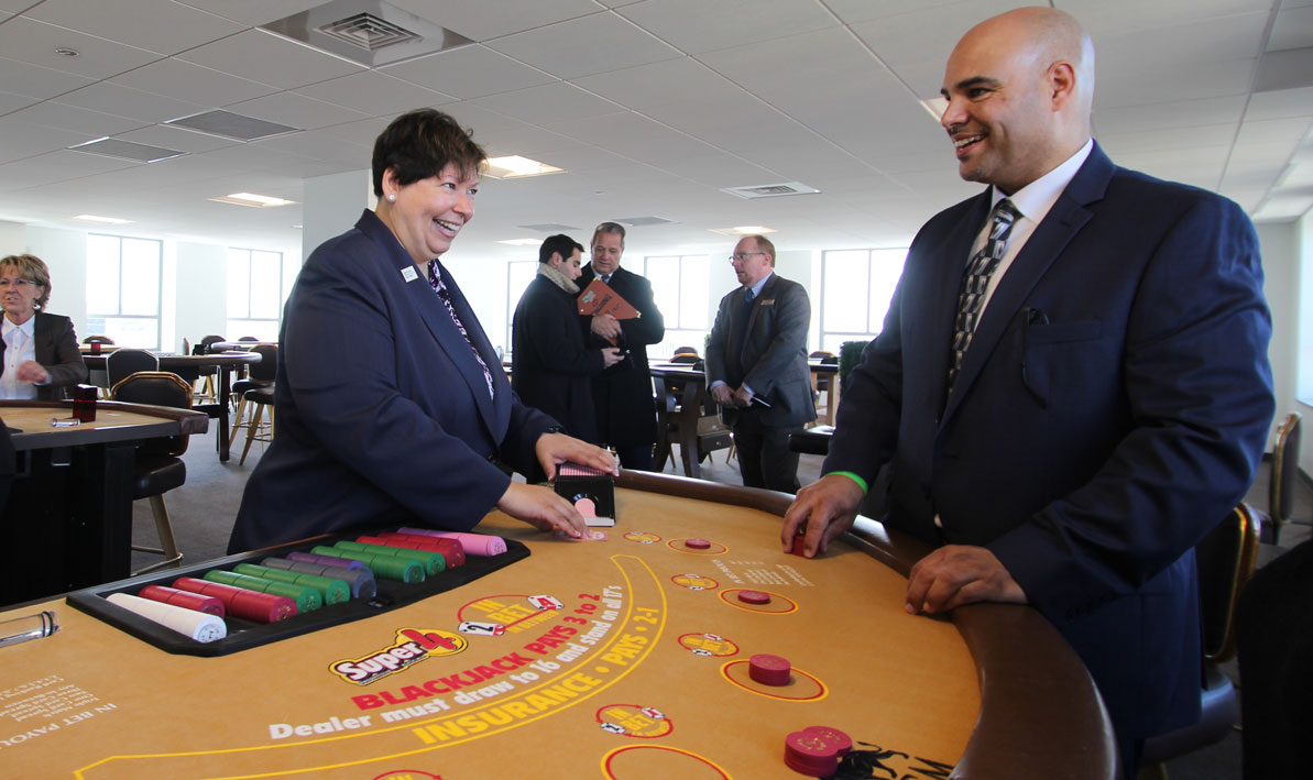 HCC president Christina Royal tests her blackjack dealing skiils as MGM trainer Angel Rivera of Springfield offers tips.