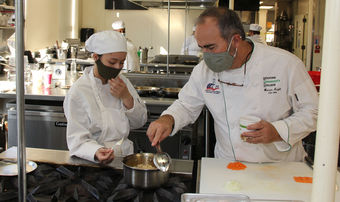 Chef Warren Leigh tastes some vegetable rice prepared by student Caroline Ortiz of Agawam 