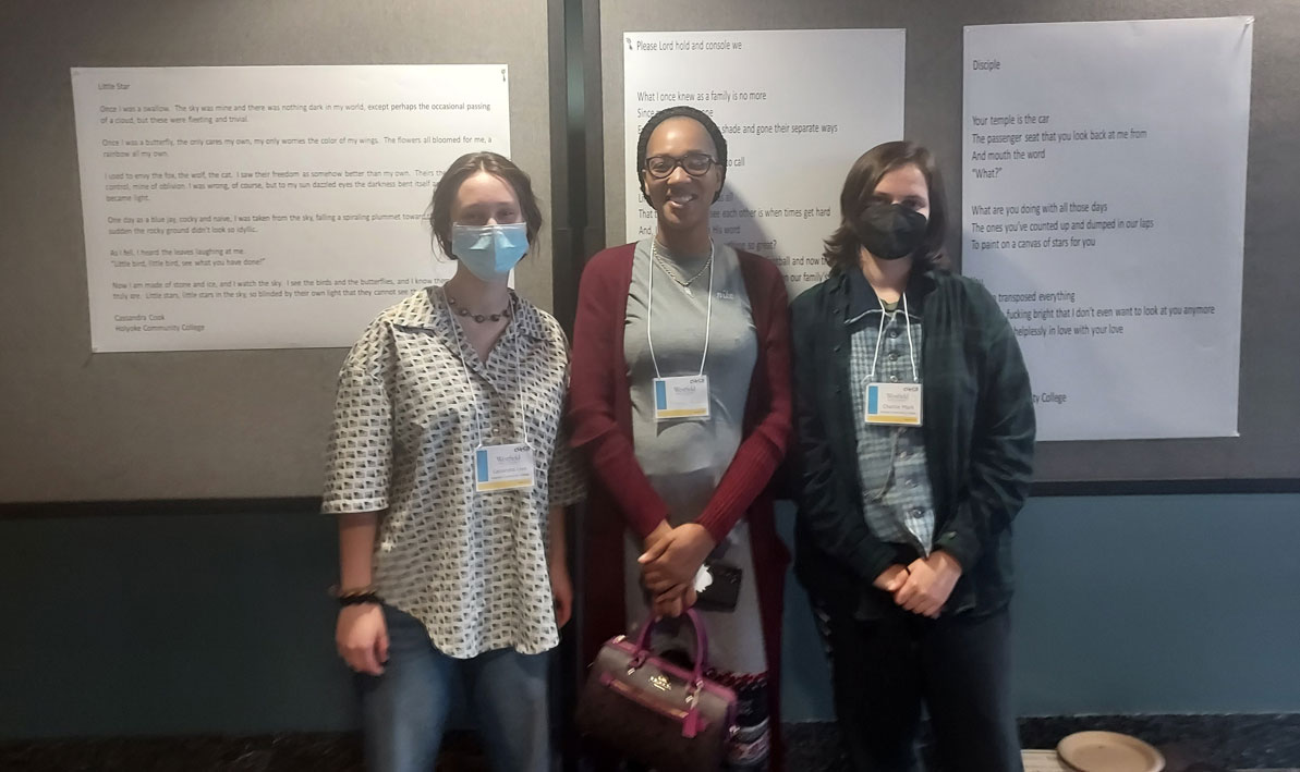 Cassandra Cook, Shonique’ Nichols, and Charlie Mark in front of their poetry.