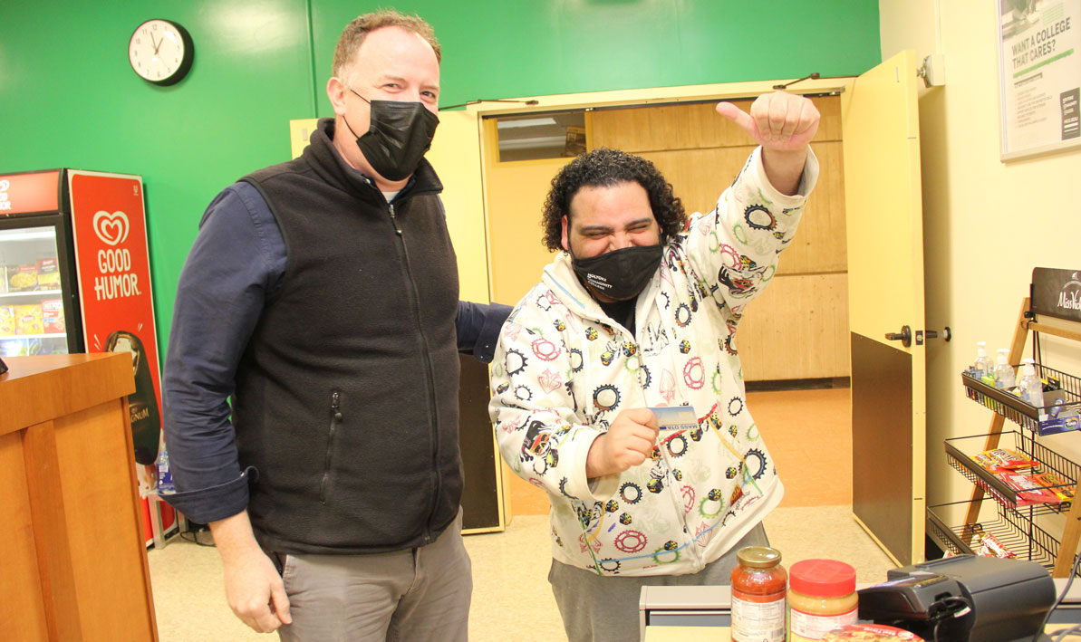 HCC food service director Kevin Vincent celebrates with HCC student Luis Pinto-Jimenez arfter the later successfully used his EBT card from the Mass. Dept. of Transitional Assistance to buy groceries at HCC's Homestead Market.