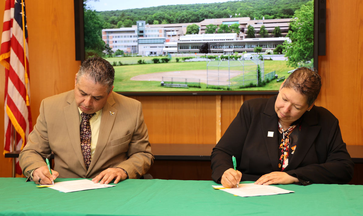 AIC President Hubert Benitez and HCC President Christina Royal shake sign 'historic' deal