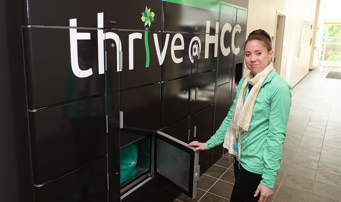 Food pantry manager Elizabeth Eastman loads groceries into a refrigerated locker outside Thrive.