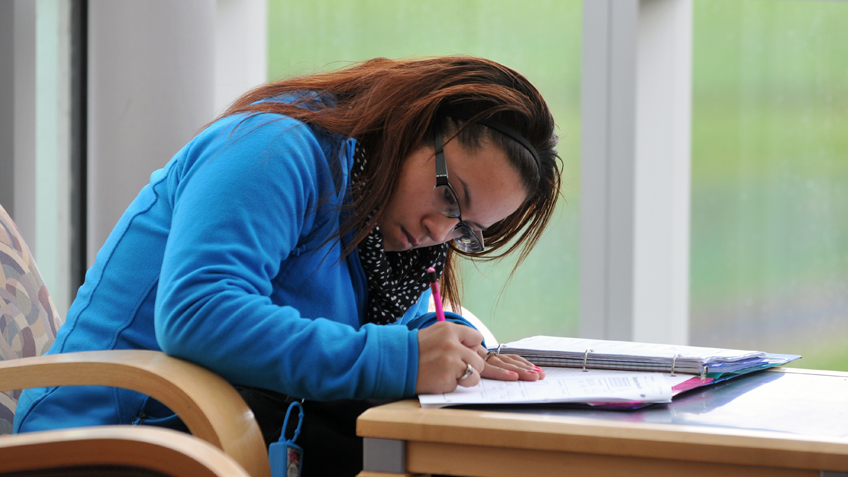 A female student writing in a notebook