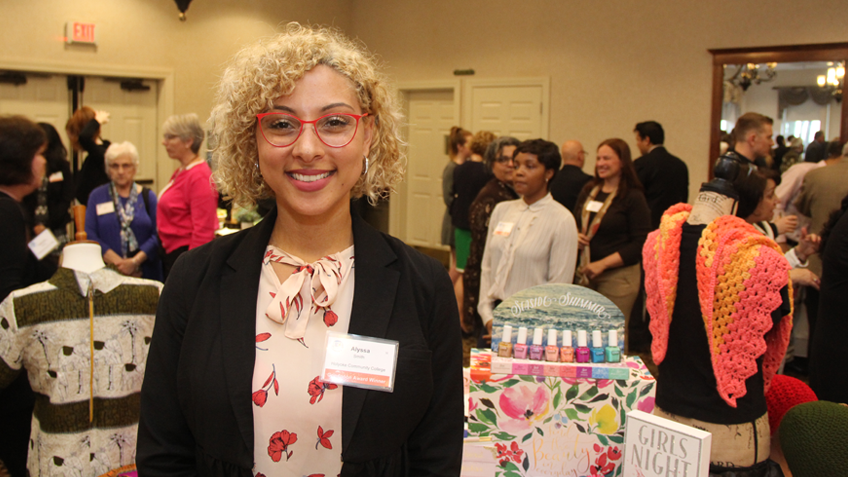 A student posing with a business presentation