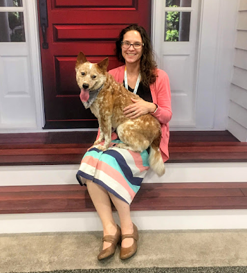 Jennifer York sitting on a front porch with a small dog sitting on her lap