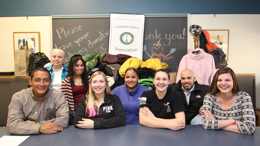 Members of the criminal justice association pose at a coat drive