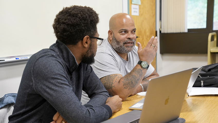 Two HCC students discuss in a classroom setting