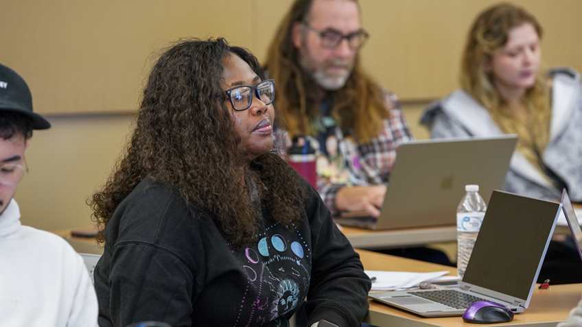 A student wearing glasses pays attention in class