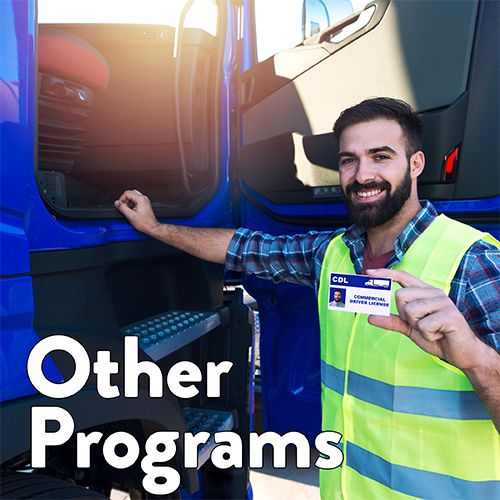 A CDL student holds up their license next to a blue truck