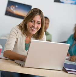 student typing paper and smiling